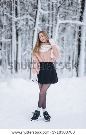 Beauty young blondie woman walking in winter park, smile and have fun outdoors