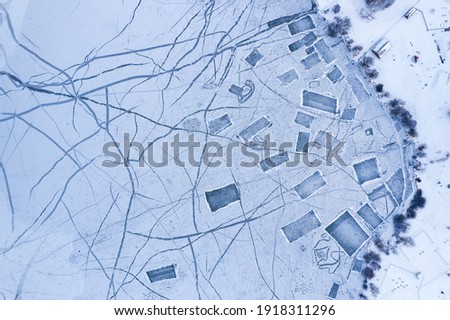 Aerial view to frozen lake with many playgrounds for ice hockey and skating rinks. Winter landscape.