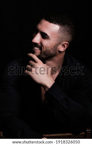 Male portrait of muscular young man in studio. Black background