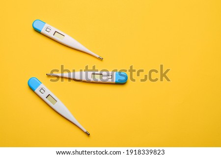 Electronic thermometers . Electronic thermometer on a yellow background. Temperature measurement. Safe thermometer. Modern medical equipment. Science and medicine. Article about safe thermometers.  Royalty-Free Stock Photo #1918339823