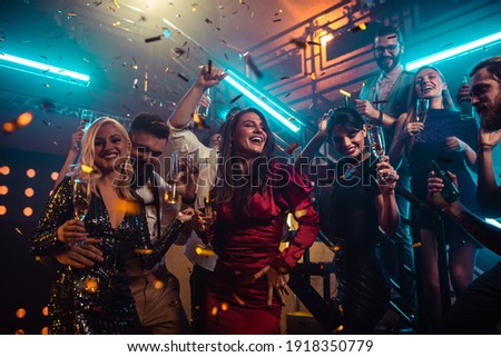 Group of friends partying in a club and moving to the music. Royalty-Free Stock Photo #1918350779