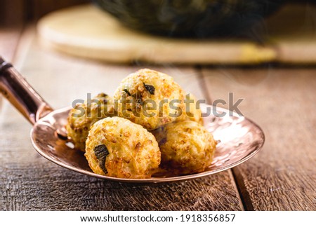 cod dumplings, fish meat dumpling in a slotted spoon, fried salty