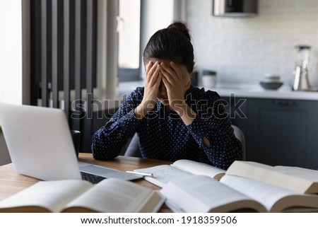 Upset millennial Indian female student feel distressed exhausted with homework assignment or preparation. Unhappy young ethnic woman stressed overwhelmed with amount of work. Deadline concept. Royalty-Free Stock Photo #1918359506