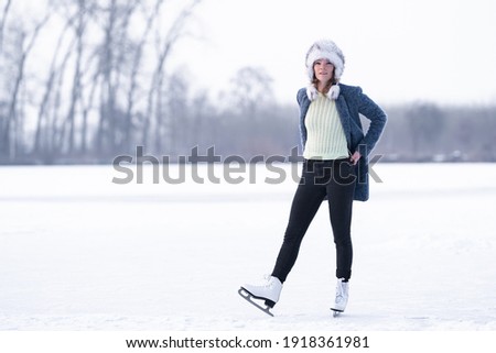 Gorgeous woman skating on frozen lake