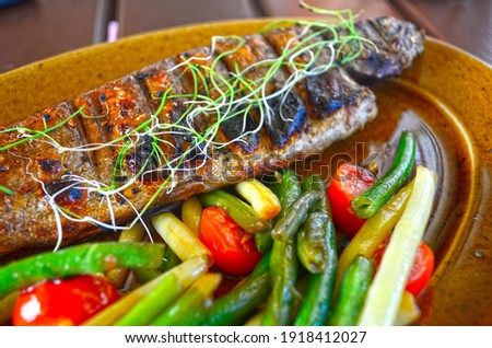 Baked trout with vegetables, restaurant serving.
