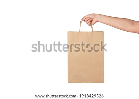 Woman hand holding brown paper bag isolated on white background. Royalty-Free Stock Photo #1918429526