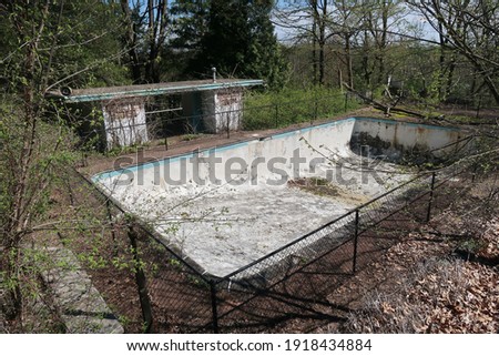Empty inground pool on an abandoned property. Seasonal.  Royalty-Free Stock Photo #1918434884