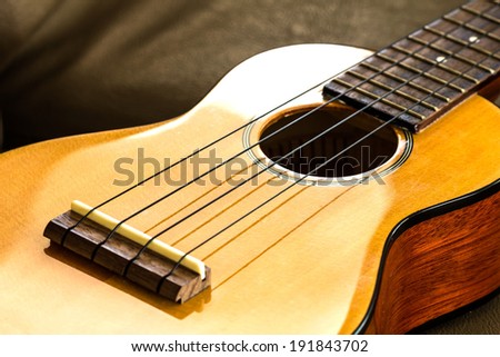 ukulele part on the leather sofa