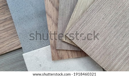 mood and tone interior material board presenting combination of wooden veneer samples and quartz stone tile samples. close up multi color and texture of veneer and artificial stone swatch.