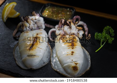 Food picture Grilled squid eaten with seafood sauce.