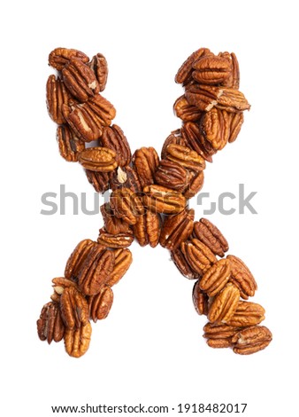 Letter X of the English alphabet from pecans on a white isolated background. Food pattern made from nuts. Bright alphabet for shops. 