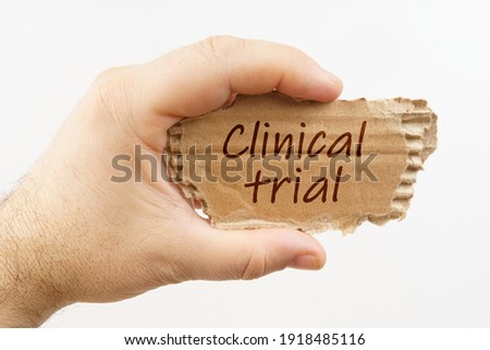 Medical. A man holds a cardboard in his hand on which it is written - Clinical trial