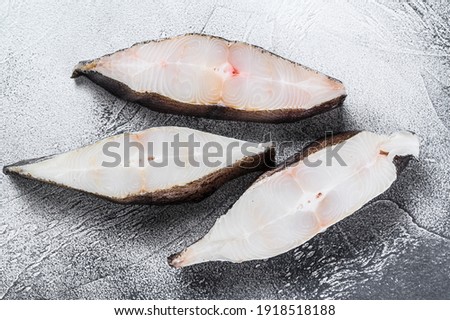 Raw fresh steak fish halibut on the stone table. White background. Top view