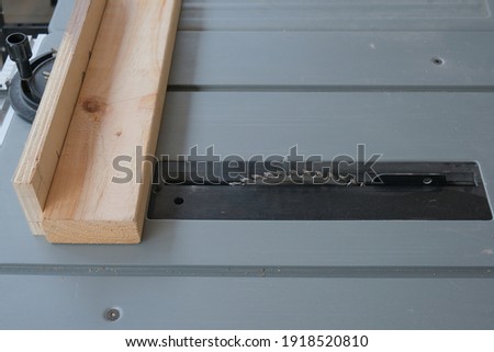 Selective focus picture of wood and splitter on saw table before cutting.