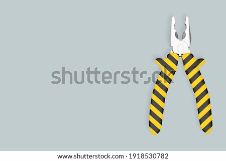 Metal pliers with rubber striped grips. Background on the theme of tools, repair, repair service center. 