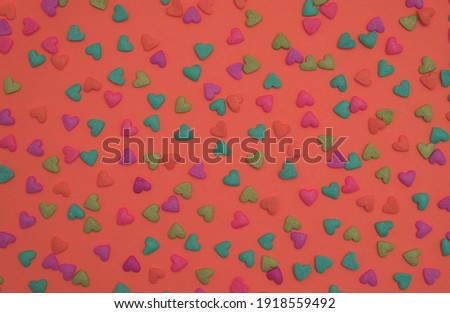 Colorful heart shape sweet candy on peach color background. Happy birthday greeting card. Holiday background. Children party background. Sweet candy concept. Minimal concept.                    