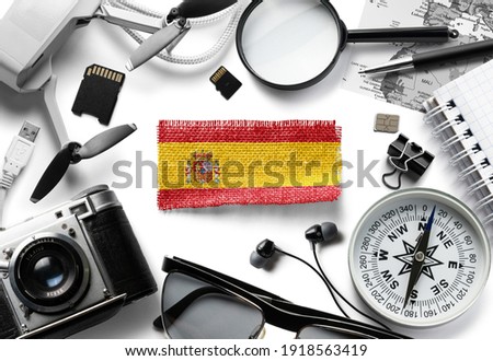 Flag of Spain and travel accessories on a white background.