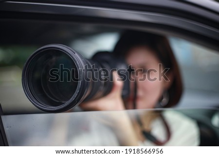 Woman taking pictures from inside the car 