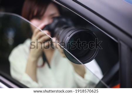 Woman taking pictures from inside the car 