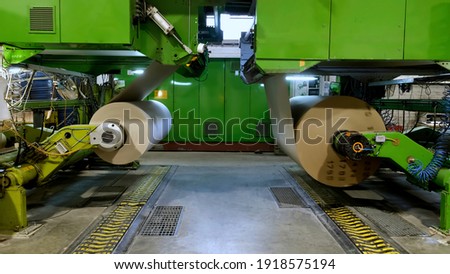 Manufacture of corrugated paper and containers of paper and paperboard. Large rolls of paper. The gap of paper. Royalty-Free Stock Photo #1918575194