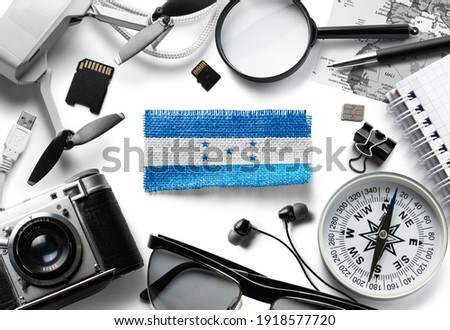 Flag of Honduras and travel accessories on a white background.