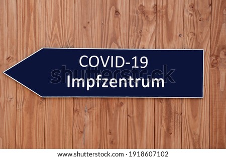 blue signpost with the inscription "COVID-19 Impfzentrum"