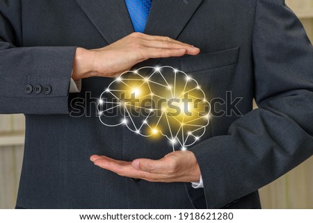 Mindset, mind control and improvement, extra sensory perception, psychology concept : Businessman holds pseudo human brain with bright lines of digital network or growing intelligent nervous system Royalty-Free Stock Photo #1918621280