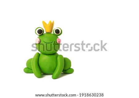 Cute plasticine frog in a crown on a white background