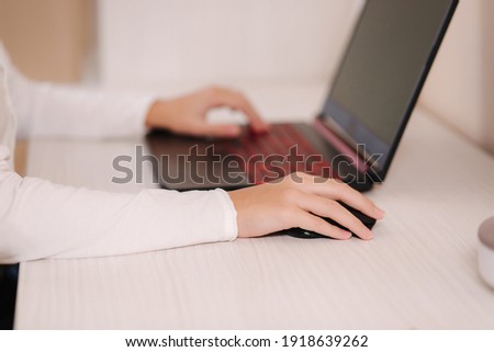 Closeup of boy playing game on his pc computer in white room. Gamer capture video on web camera on laptop. Focus on hand