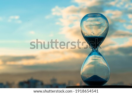 Hourglass and city at sunset Royalty-Free Stock Photo #1918654541