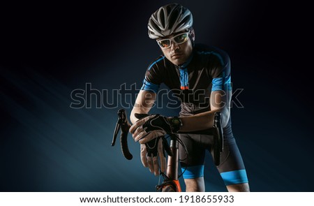 Spost background with copyspace. Cyclist. Dramatic colorful close-up portrait. Royalty-Free Stock Photo #1918655933