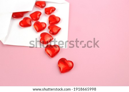Red hearts pouring out of a white envelope