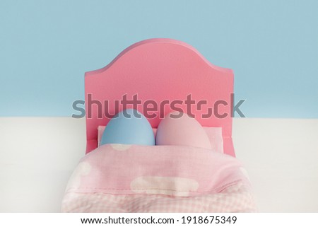 Lovely couple eggs sleeping in an embrace in bed. holding hands.Easter holiday concept with cute eggs with funny faces. Different emotions and feelings. 
