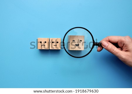Wooden cubes with icons of emotions: JOY, CALM, SADNESS. A person makes a choice in favor of joy and optimism Royalty-Free Stock Photo #1918679630