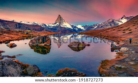 Photographer takes picture of Stellisee lake with Matterhorn peak on background. Unbelievable  autumn sunrise on Swiss Alps, Zermatt resort location, Switzerland, Europe. 