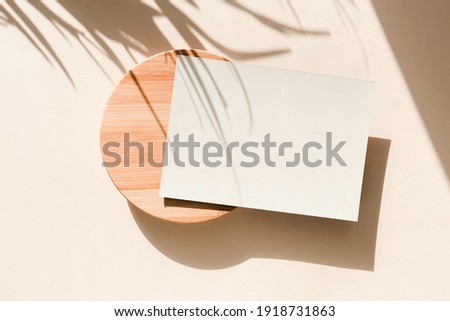 Card on beige background with palm leaves shadows. Minimal concept mock up background. Top view.