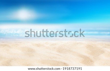 Natural blurred defocused background for concept summer vacation. Nature of tropical summer beach with sun in haze. Light sand beach, ocean water sparkles against blue sky.