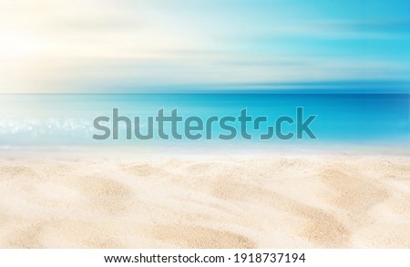 Summer background image of tropical beach with blurred horizon at sunset. Light sand of beach against backdrop of sparkling ocean water. Natural seascape. Royalty-Free Stock Photo #1918737194