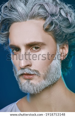 Art close up portrait image of God. Divine man with a gray beard and curly hair on a blue background. Roman and Greek mythology, Christianity and religion.