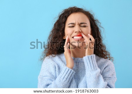 African-American woman with gum inflammation on color background Royalty-Free Stock Photo #1918763003