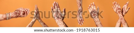 Beautiful female hands with henna tattoo on color background