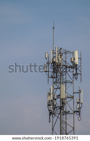 5G telecommunication tower 5G mobile phone wireless antenna machine Located in the center of the city against a blue sky background.