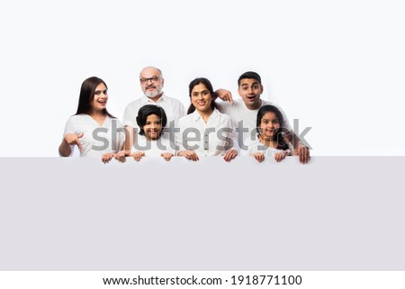 Multigenerational Indian asian family with white board, pointing or presenting empty white placard Royalty-Free Stock Photo #1918771100
