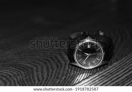 the dial clock is placed on a wooden surface. Black and white photo.