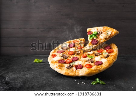 Supreme Pizza with pepperoni, mushrooms and mozzarella cheese just from oven, copy space. Fresh homemade pizza. Royalty-Free Stock Photo #1918786631