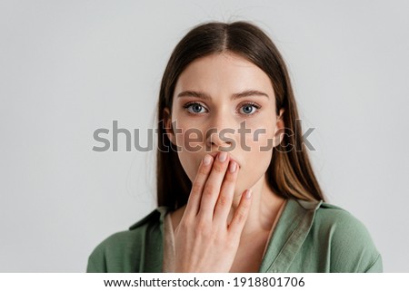 Surprised caucasian girl covering her mouth and looking at camera isolated over white background Royalty-Free Stock Photo #1918801706