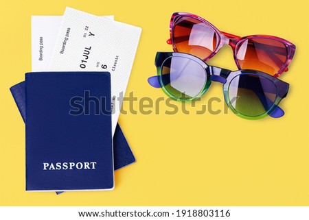 Two blue passports, boarding pass, flight ticket, sunglasses on yellow background close up top view, airplane travel, passenger check in, summer holidays, vacation, international tourism, copy space