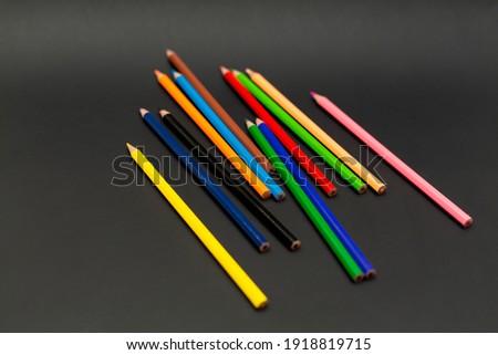 Several colored pencils, isolated on a black background.