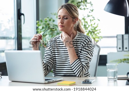 Tired mature business woman with a sore throat looking uncomfort Royalty-Free Stock Photo #1918844024