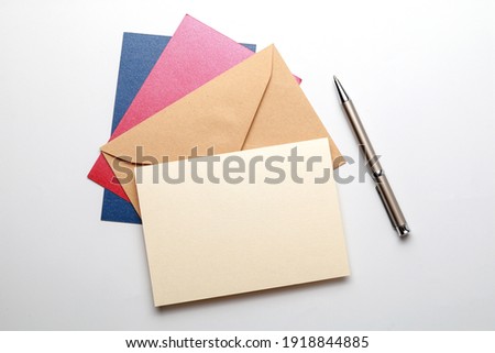 Envelope with blank card and pen isolated on white background. Top view